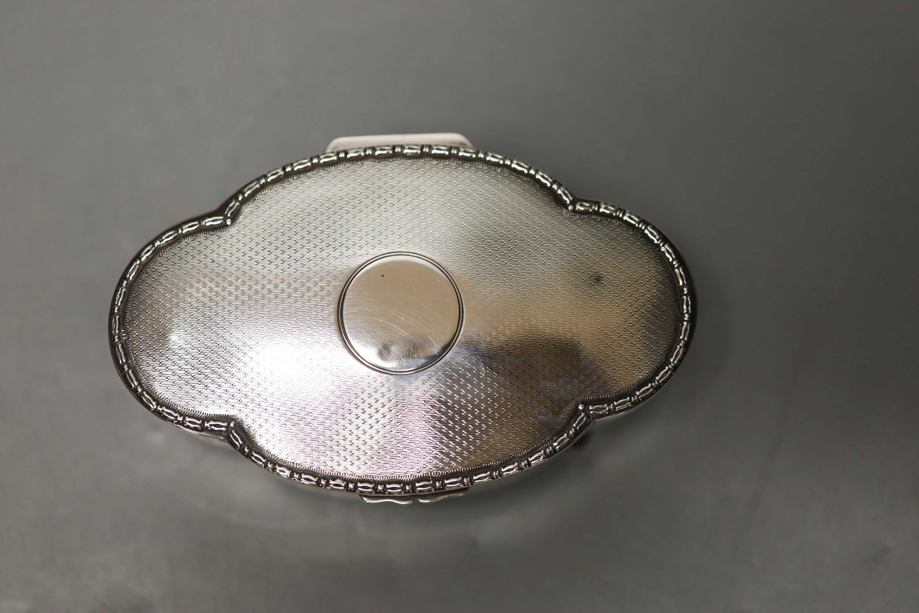 A George V part engine turned silver mounted shaped oval trinket box, Birmingham, 1911, 13.2cm.